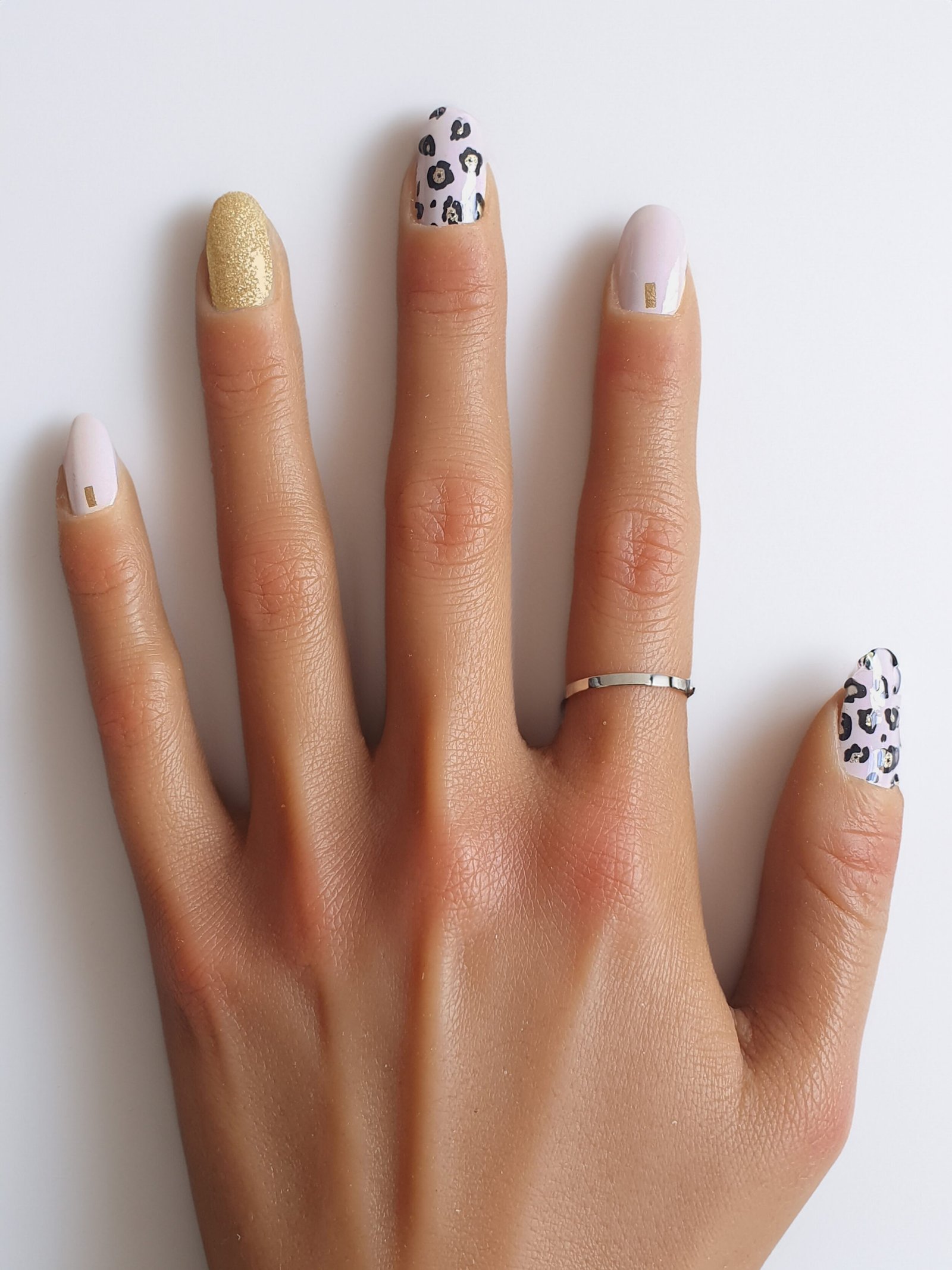 Manucure avec stickers ongles léopard et pailletés dorés, parfaite pour un look chic et audacieux.