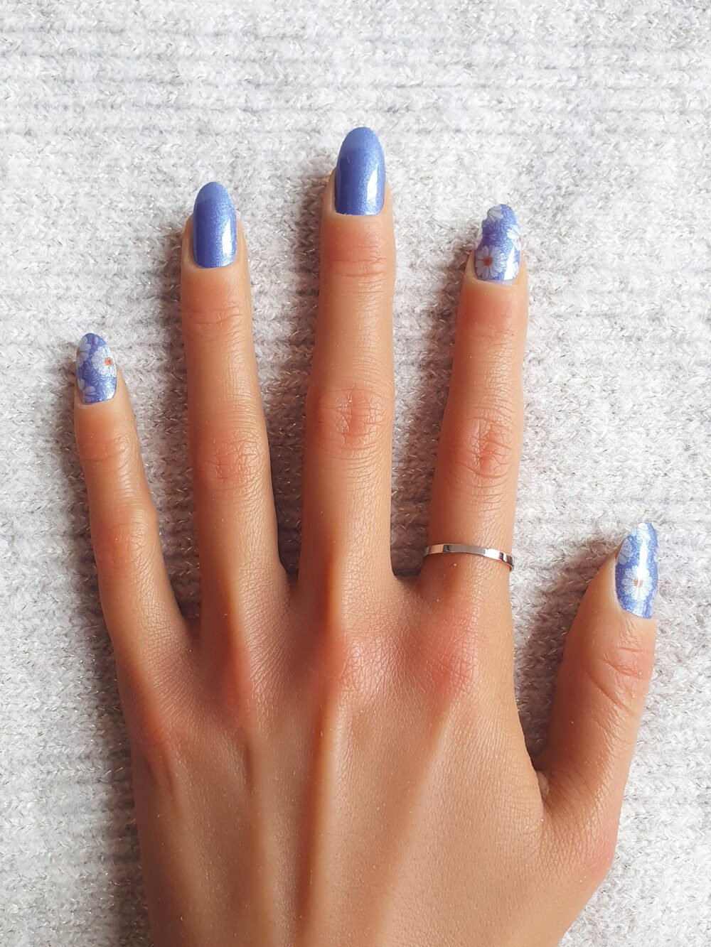 Conforme aux tendances nail art, manucure bleue et motifs de fleurs