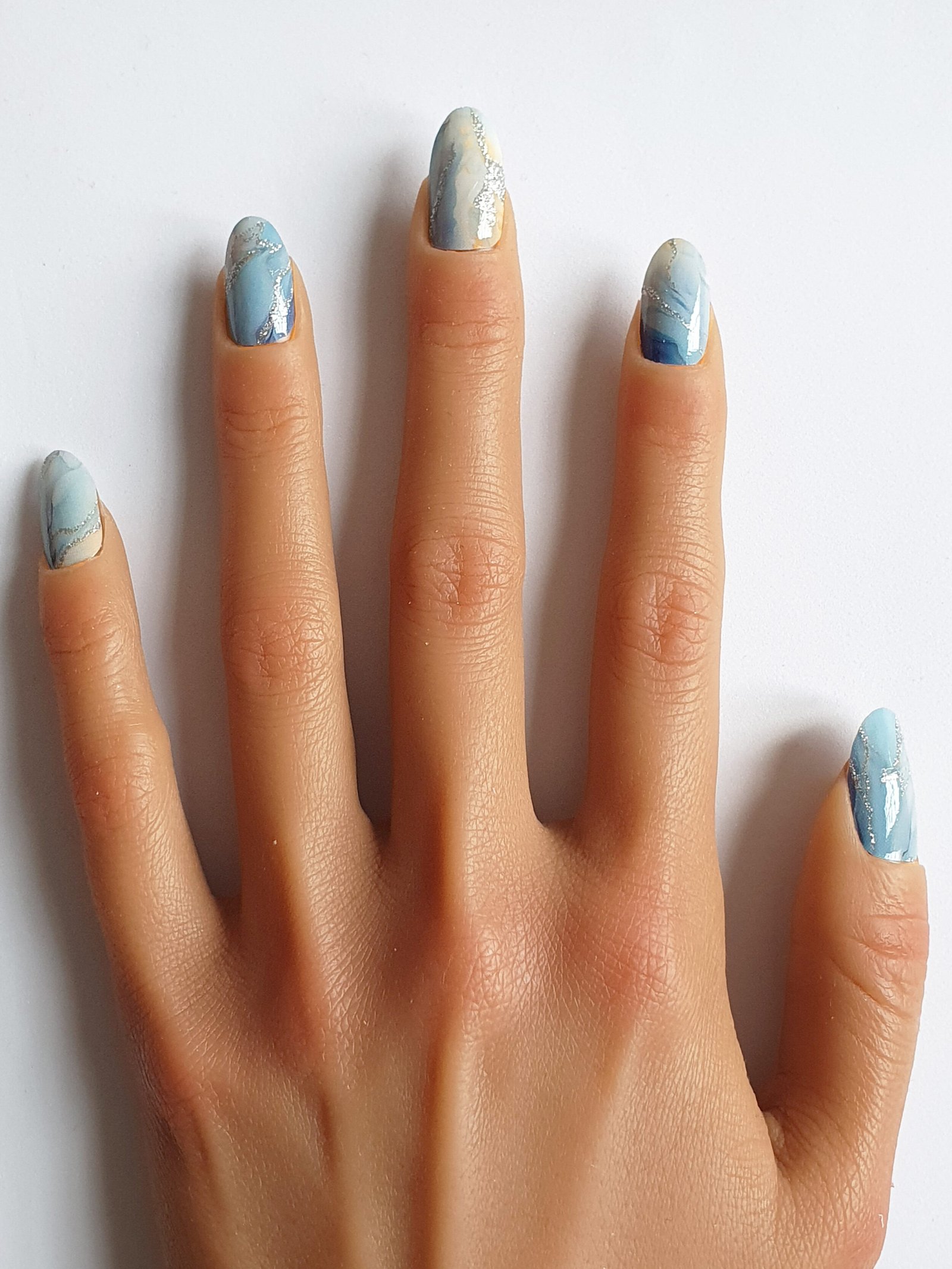 Ongles effet marbré aux nuances bleues et argentées, parfaits pour une manucure marbrée tendance.